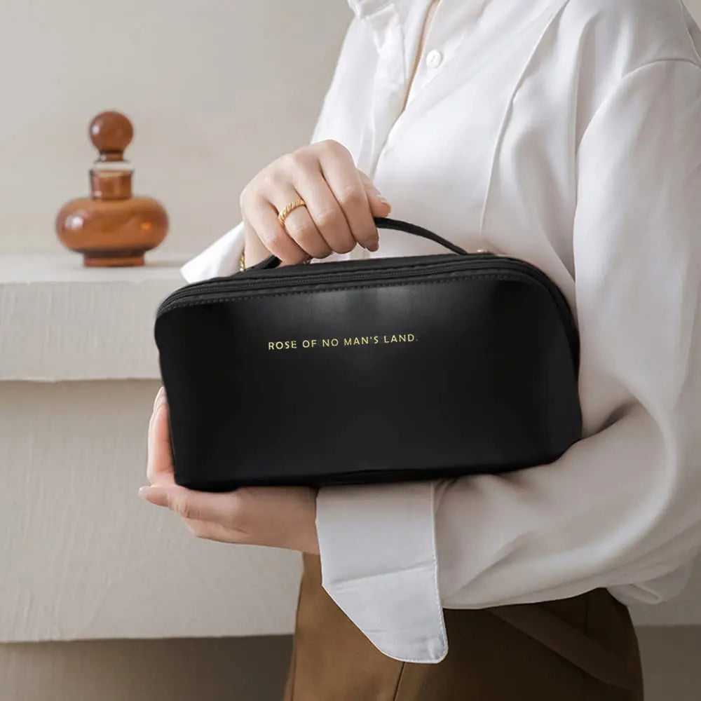 a woman holding a black bag with the words work of land printed on it