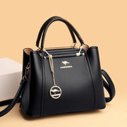 a black handbag sitting next to a white box