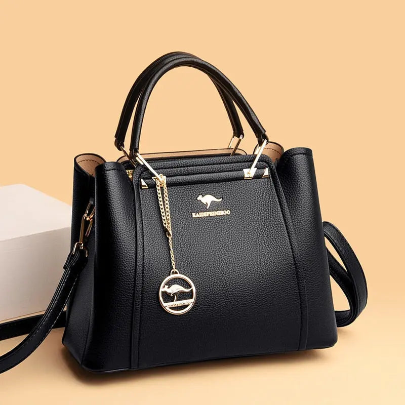a black handbag sitting next to a white box